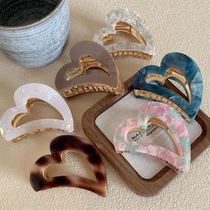 Set of six colorful acetate heart hair claws featuring diverse marble and floral patterns