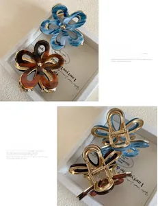 Detailed close-up of blue marble and tortoiseshell acetate flower hair claws with metal grip