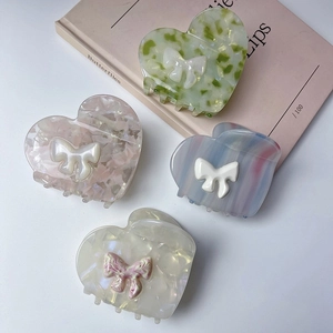 Set di quattro mollette a cuore in acetato con fiocchi in motivi marmorei e floreali
