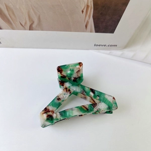 Detailed view of large acetate hair claw clip with triangle design and tortoise pattern