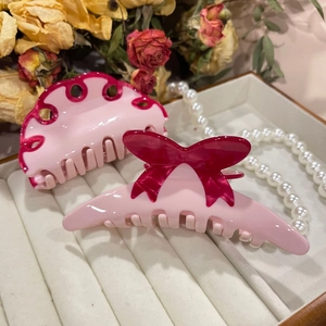 Haarklammer-Set mit rosa Schleife und gewelltem Design aus Acetat auf Schmucktablett