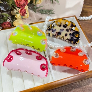 Set of four colorful acetate hair claws with wave design in a decorative jewelry box