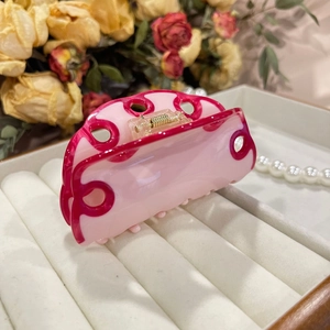 Close-up of pink and magenta acetate hair claw clip with unique wave ring design