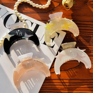 Detail of crescent moon hair claws with stars and rhinestones in four elegant colors