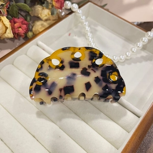 Close-up of tortoiseshell acetate claw clip with ring design in elegant gift box