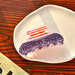 Détail d'une grande pince à cheveux drapeau américain sur une assiette en céramique