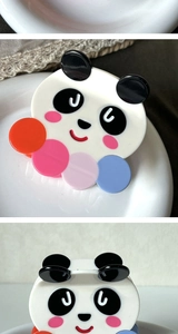 Détail d'une pince à cheveux panda mignonne en acétate avec des boules décoratives