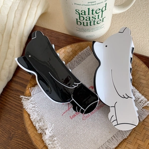 Cute black and white bear acetate hair claws in a cozy lifestyle setting with rustic decor