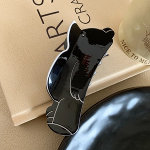 Detailed view of a cute bear-shaped cellulose acetate hair claw clip with glossy finish