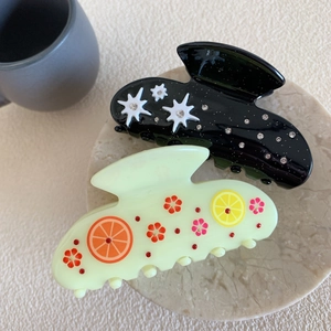 Elegant acetate hair claws with rhinestone star and citrus fruit slice patterns