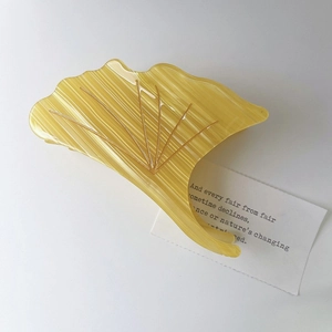 Detailed view of yellow ginkgo leaf hair claw clip with elegant acetate ribbed texture