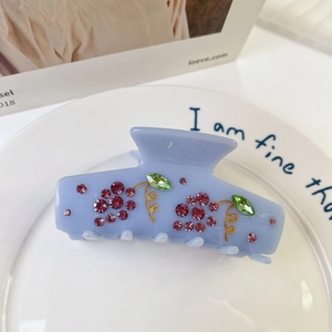 Close-up of acetic acid hair claw with sparkling rhinestone grape and vine patterns