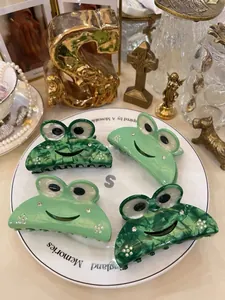 Detailansicht von vier Frosch-Haarklammern aus Acetat in Glanz- und Marmorgrün mit Strass