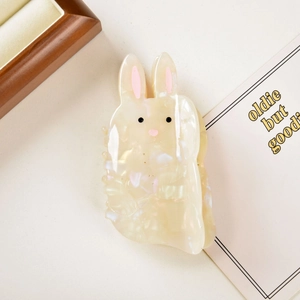 Detail of a rabbit-shaped acetate hair claw clip with pearly white marble texture