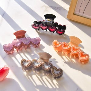 Set aus vier herzförmigen Haarklammern aus Acetat in Pastellfarben auf Marmorplatte