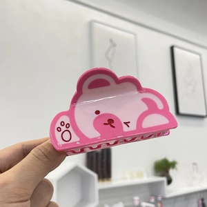 Détail de la pince à cheveux en acétate rose avec motifs d'ours et pattes mignons