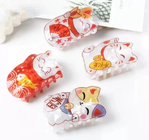 Détail de quatre pinces à cheveux Maneki Neko avec motifs traditionnels de chat porte-bonheur