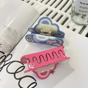Détail de pinces à cheveux en forme d'ours bleu pastel et rose sur un fond lifestyle