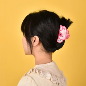 Pince à cheveux rose en forme de cochon en acétate brillant pour chignon sur fond jaune vif
