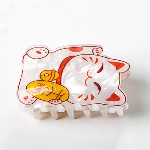 Détail de la pince à cheveux chat porte-bonheur blanc nacré avec accents colorés