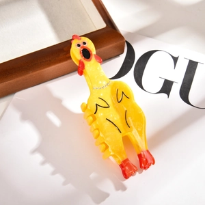 Détail d'une pince à cheveux en acétate en forme de poulet avec décoration en strass
