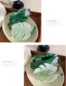 Detail of leaf-shaped acetate hair claws in dark green and light green marble finish