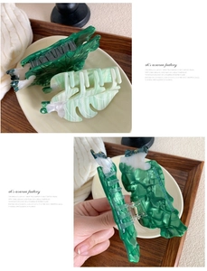 Close-up of green marble acetate hair claw clips with metal springs for daily use