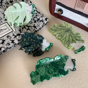 Set of four green acetate hair claws featuring leaf designs with marble patterns