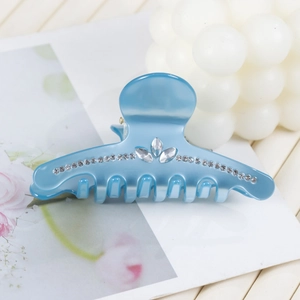 Vue détaillée de la pince à cheveux en acrylique bleu clair avec strass en forme de feuille
