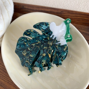 Detailed view of monstera leaf acetate hair claw clip with shell texture and rhinestones