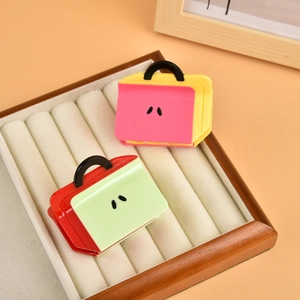 Close-up of cute handbag-shaped hair claws in pink, yellow, and green colors