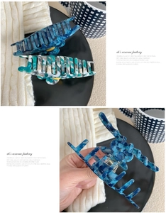 Détail de pinces à cheveux en acétate avec marbre bleu foncé et motifs floraux tricolores