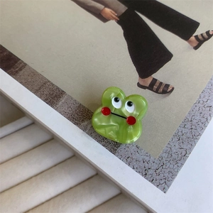 Detail view of a green acetate hair claw clip with marble texture and monster eyes