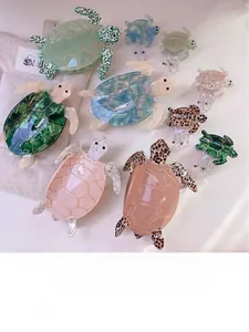 Detailed view of various turtle shaped acetate hair claws in multiple colors and sizes