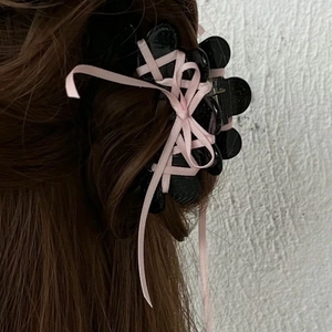 Vue détaillée de la grande pince à cheveux noire avec ruban et nœud rose style ballet