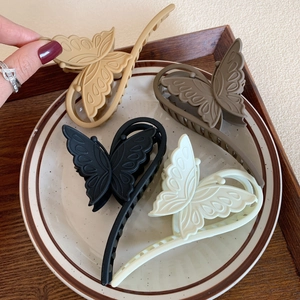 Matte butterfly hair claws in cream, brown, and black colors for women's hairstyling