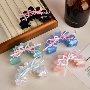 Détail de pinces à cheveux en acétate style balletcore avec nœuds en satin colorés