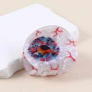 Detail of creative eyeball hair claw clip with red blood vessels and blue-red iris