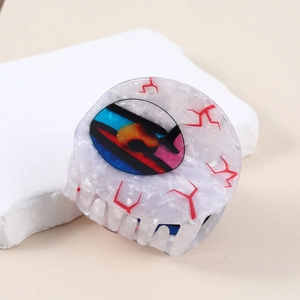 Macro detail of the evil eye hair claw clip with colorful pupil design and acetate texture