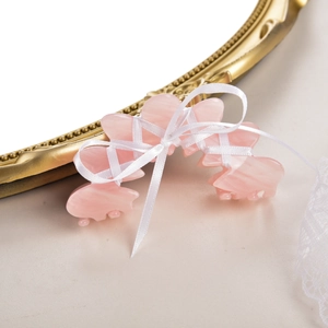 Gros plan d'une pince à cheveux rose avec ruban de ballet blanc et décor en dentelle