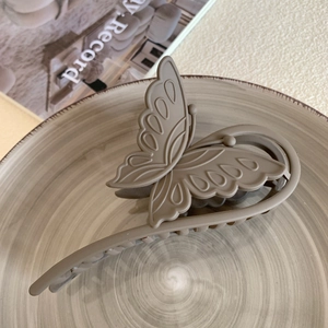 Detailed macro view of large matte butterfly claw clip in mocha brown for thick hair