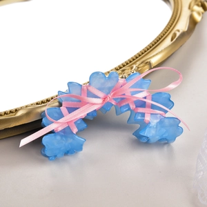 Détail d'une pince à cheveux balletcore avec cœurs bleus et nœud en ruban rose