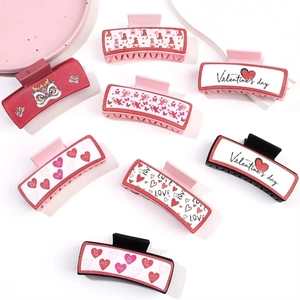 Flachbild von rosa Herz-Haarklammern und Valentinstag-Haarclips auf weißen Requisiten