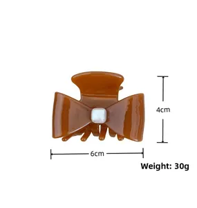 Detailed view of brown bow hair claw with dimensions of 6cm width and 30g weight