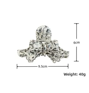 Détail de la pince à cheveux en acétate à motif marbré avec dimensions 9,5 cm et 6 cm