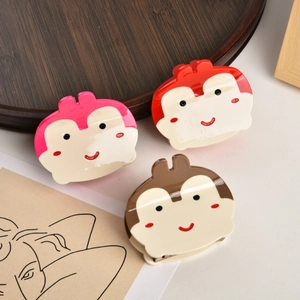 Vue détaillée de trois pinces à cheveux singe mignonnes en rose, rouge et marron