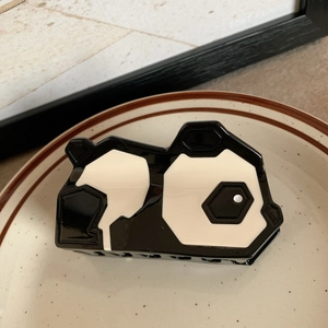Detailansicht der Panda-Haarklammer aus Acetat-Material auf einem Keramikteller