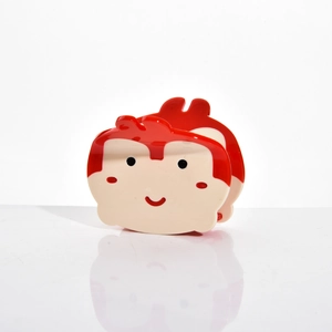 Détail d'une pince à cheveux singe mignon en résine d'acétate rouge et crème