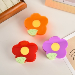 Tre fermagli per capelli a fiore nei colori arancione, viola e rosso con foglia