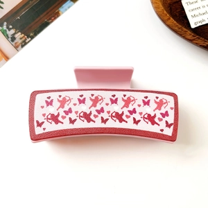Detailansicht der rosa PU-Haarklammer mit romantischem Amor- und Herzmuster-Design